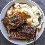 Braised Beef Short Ribs on a plate with mashed potatoes.