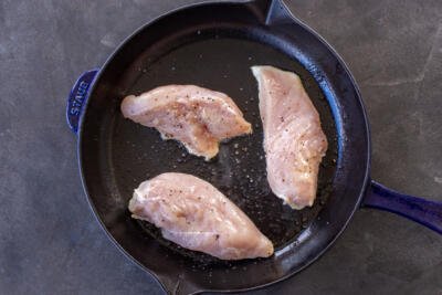 Chicken browning in a pan.