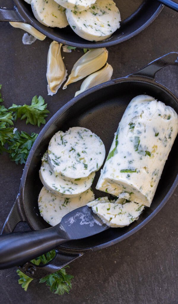 Sliced up butter in a pan with a knife. 