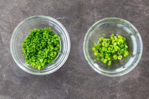 Parsley and onion diced in two bowls.