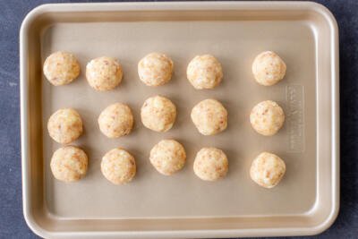 Cake balls shaped on a baking sheet.