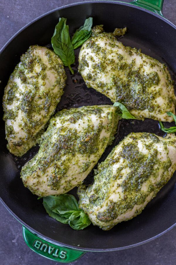Pesto Chicken Breast on a pan with fresh basil.
