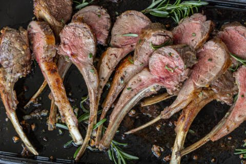 Roasted Rack of Lamb on a serving tray with rosemary.