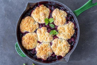 Baked Blackberry Cobbler in a pan with mint.