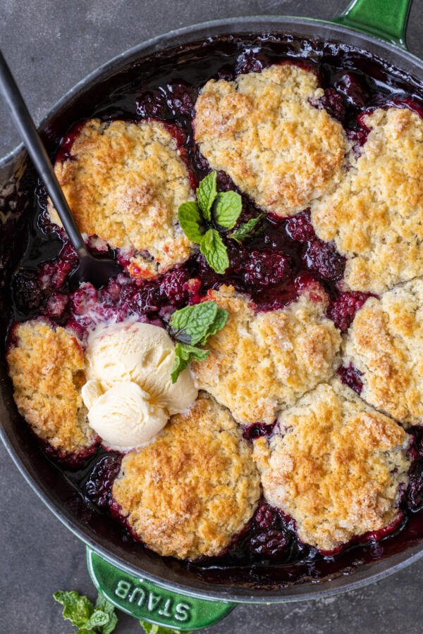 Baked blackberry cobbler in a pan with ice cream. 