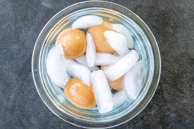 Cooked eggs in a bowl with ice.