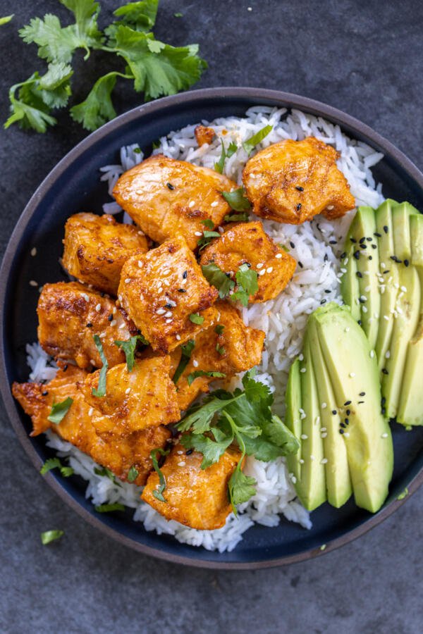 Air Fryer Salmon Bites on a plate with rice and avocado. 