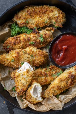 Baked Chicken Tenders on a tray with dipping sauce.