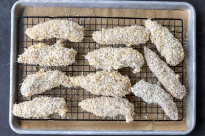 Prepared chicken tenders on a baking tray.