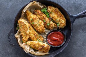 Baked chicken tenders on a pan.