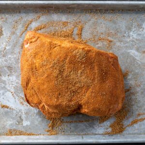 Seasoned pork roast on a baking sheet.