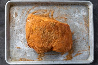 Seasoned pork roast on a baking sheet.
