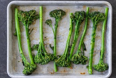 Roasted broccolini on a roasted tray.