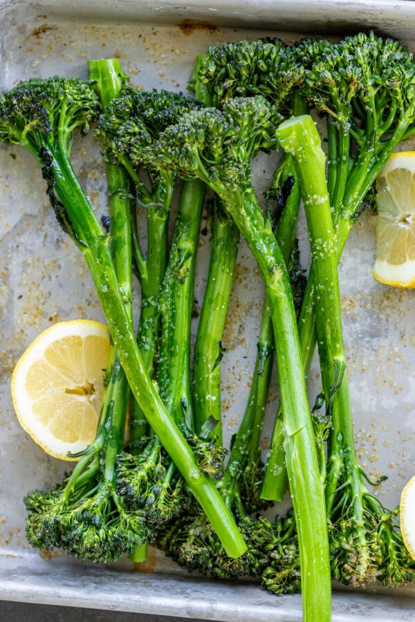 Roasted Broccolini on a serving tray with lemon.