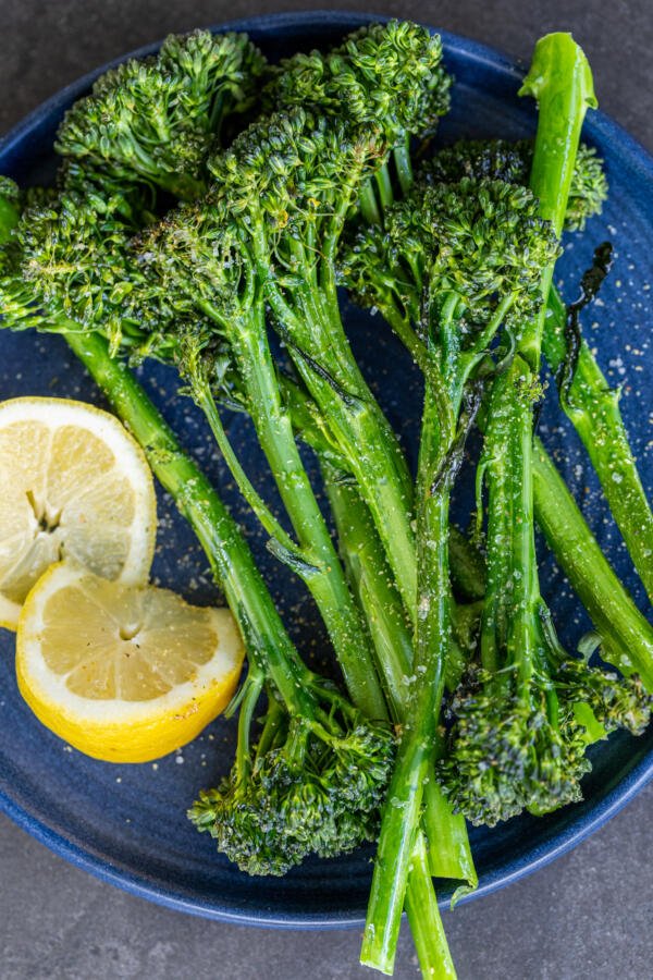 Roasted Broccolini on a plate with lemon.