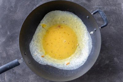 Whisked eggs cooking in a pan.