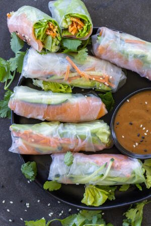 Spring Rolls With Salmon on a plate with dipping sauces.
