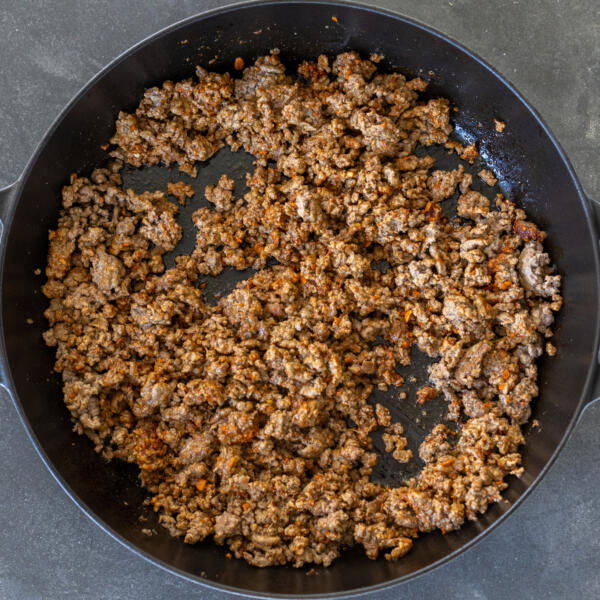 Seasoned cooked ground beef in a pan.