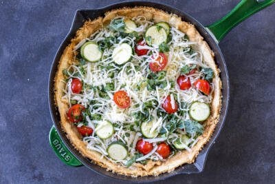 Pie crust with veggies and cheese.