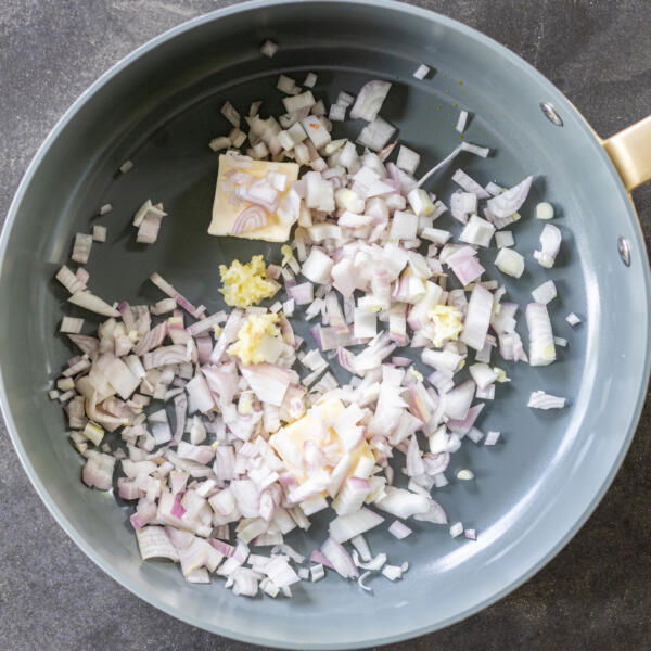 Scallions with garlic and butter in a pan.