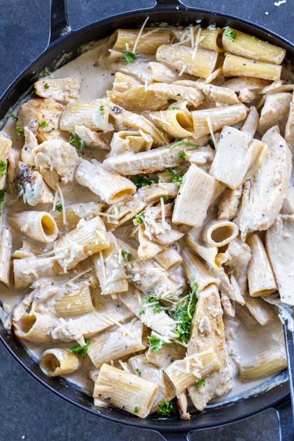 Creamy Chicken Pasta in pan with herbs. 