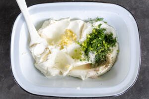 Cream cheese and herbs in a bowl.