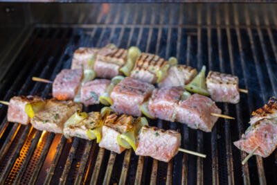 Salmon kebabs on a grill.