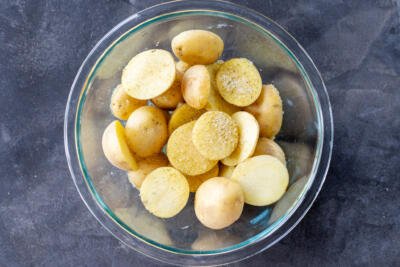 Potatoes with seasoning in a bowl.