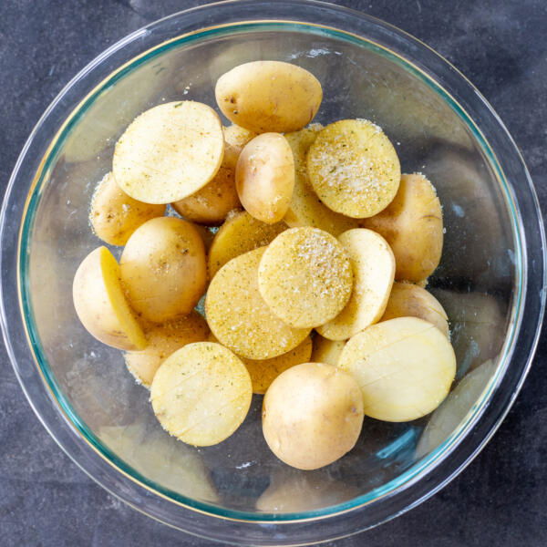 Potatoes with seasoning in a bowl.
