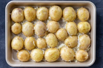 Potatoes with cheese in a baking pan.
