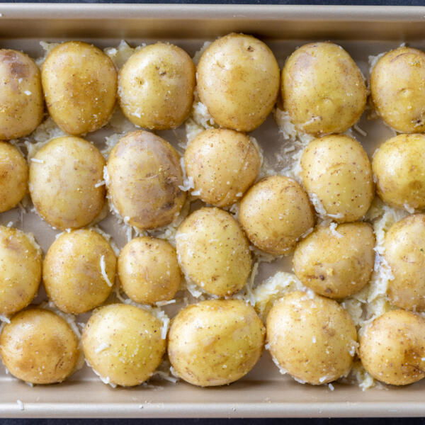 Potatoes with cheese in a baking pan.