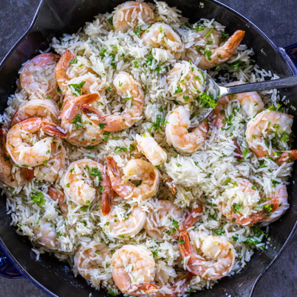Shrimp & Rice in a pan with parsley and a serving spoon.