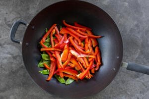 Bell peppers and snow peas in a pan.