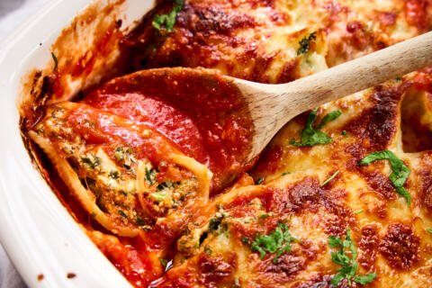 Pan with Spinach Stuffed Shells and spoon.