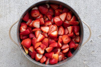 Cut up strawberries in a pot.