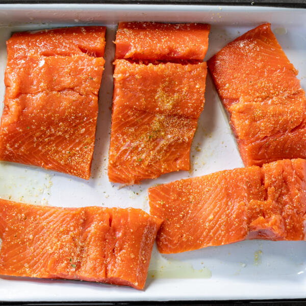 Seasoned salmon on a tray.