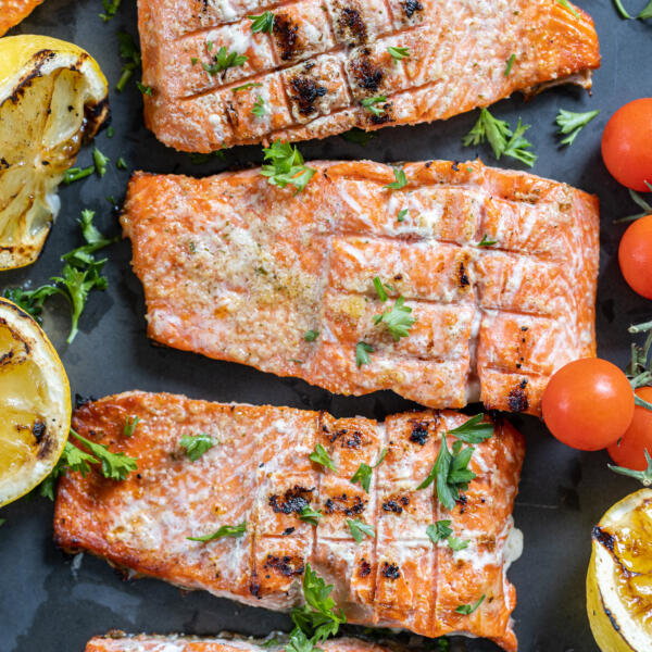 Grilled salmon with veggies next to it.