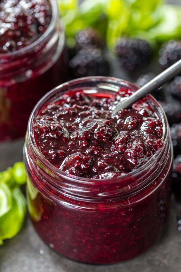 Jar with Blackberry Jam and a spoon inside. 
