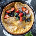 German Pancake in a pan with powdered sugar with berries.