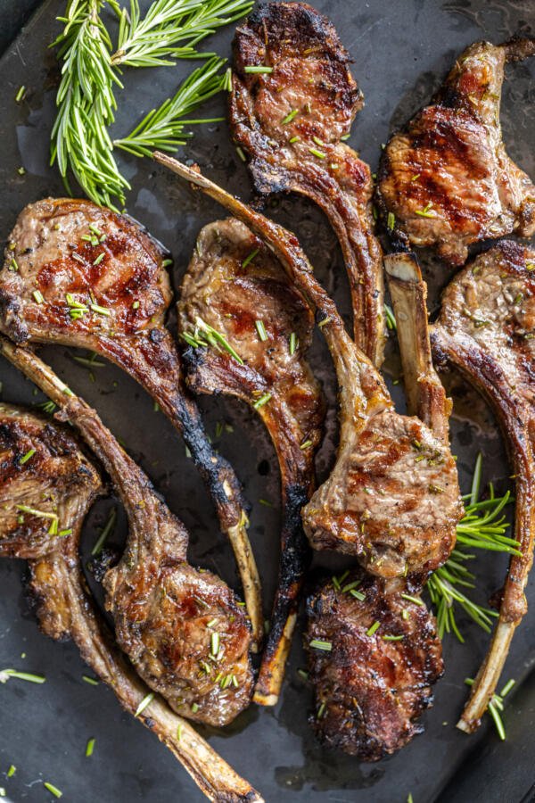 Grilled Lamb Chops on a tray with herbs.