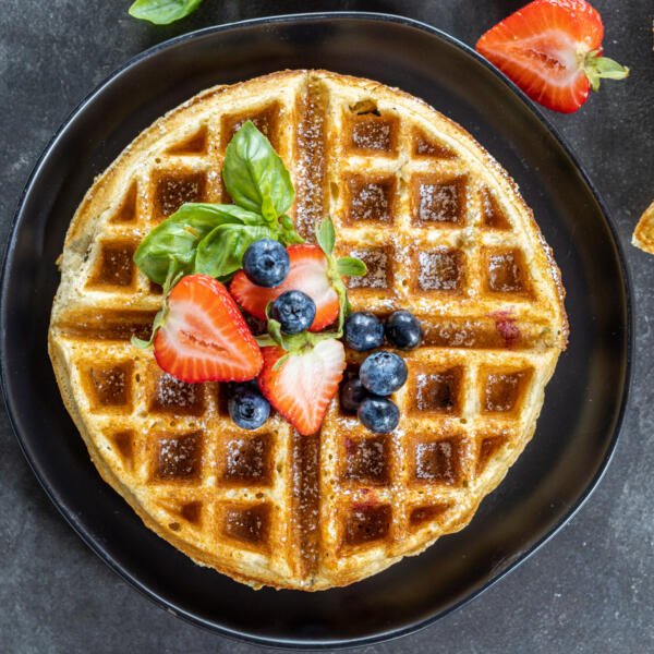 Oatmeal Cottage Cheese Waffles on a plate with berries.