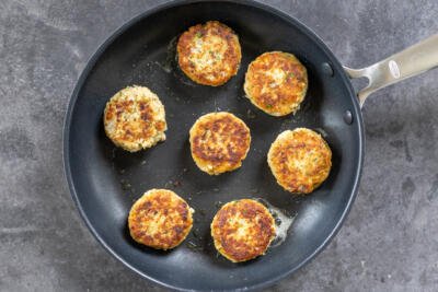 Frying salmon cakes in a pan.