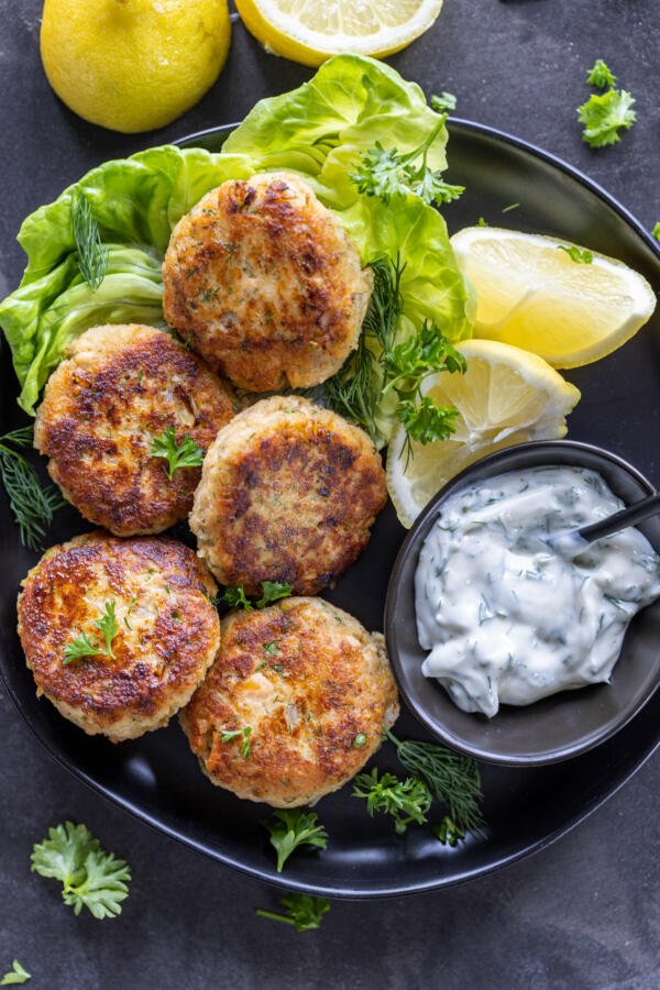 Salmon cakes with dipping sauce on a tray. 