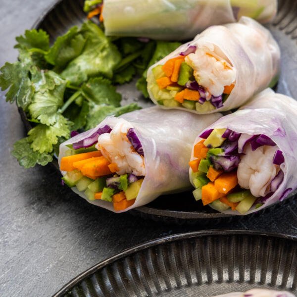 Spring rolls on a plater with herbs.