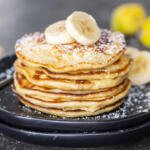 a stash of Banana Pancakes on a plate with a spoon.