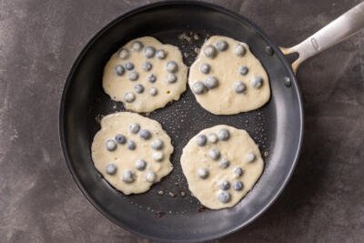 Blueberry pancakes in pan.