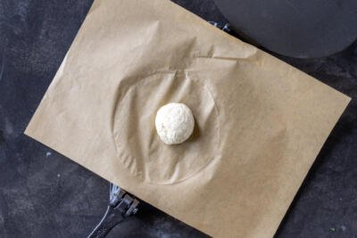 A dough ball in a tortilla press.