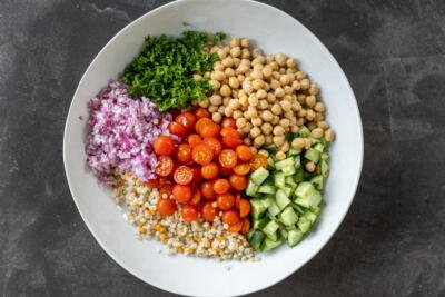 Israeli Couscous Salad ingredients in a bowl.