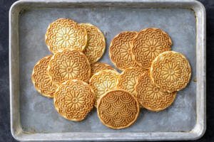 Pizzelle on a baking sheet.
