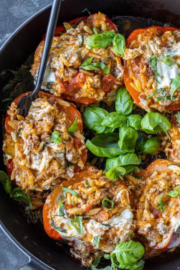 Baked Italian Stuffed Peppers in a pan with basil.
